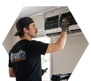 Tech cleaning a heat pump