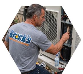 Tech cleaning a heat pump
