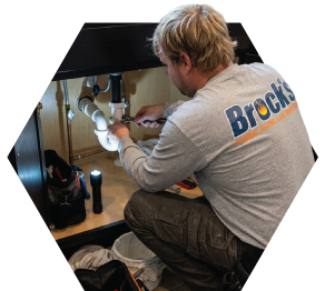 Brock's plumber working on a sink